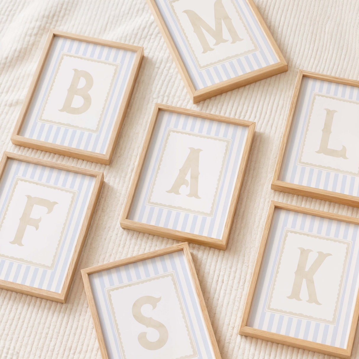 "A–Z initial letter prints in pastel blue stripes and neutral beige for kids room wall art"