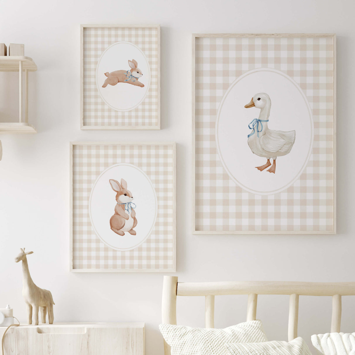 Set of three watercolor baby animal nursery prints: bunny with scarf, bunny with bow, goose with bib on a gingham background.
