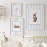 Blue nursery wall decor with baby animals in frames for gender neutral room.

