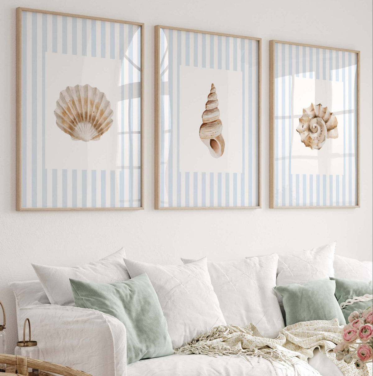 Blue seashell wall art set of 6 printable coastal prints featuring watercolor seashells and starfish on light blue striped backgrounds for beach house nursery and bathroom decor.