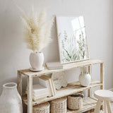 Nature wall art trio with light wood frames in minimal room

