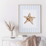 Seashell gallery wall printable set with blue stripes starfish and ocean shell illustrations for beach house wall decor.