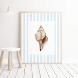 Coastal nursery wall art with blue striped backgrounds and neutral watercolor seashells for baby boy nursery decor.